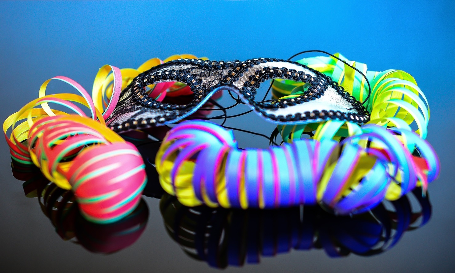 Karnevalsmaske mit bunten Luftschlangen liegen auf einem Tisch