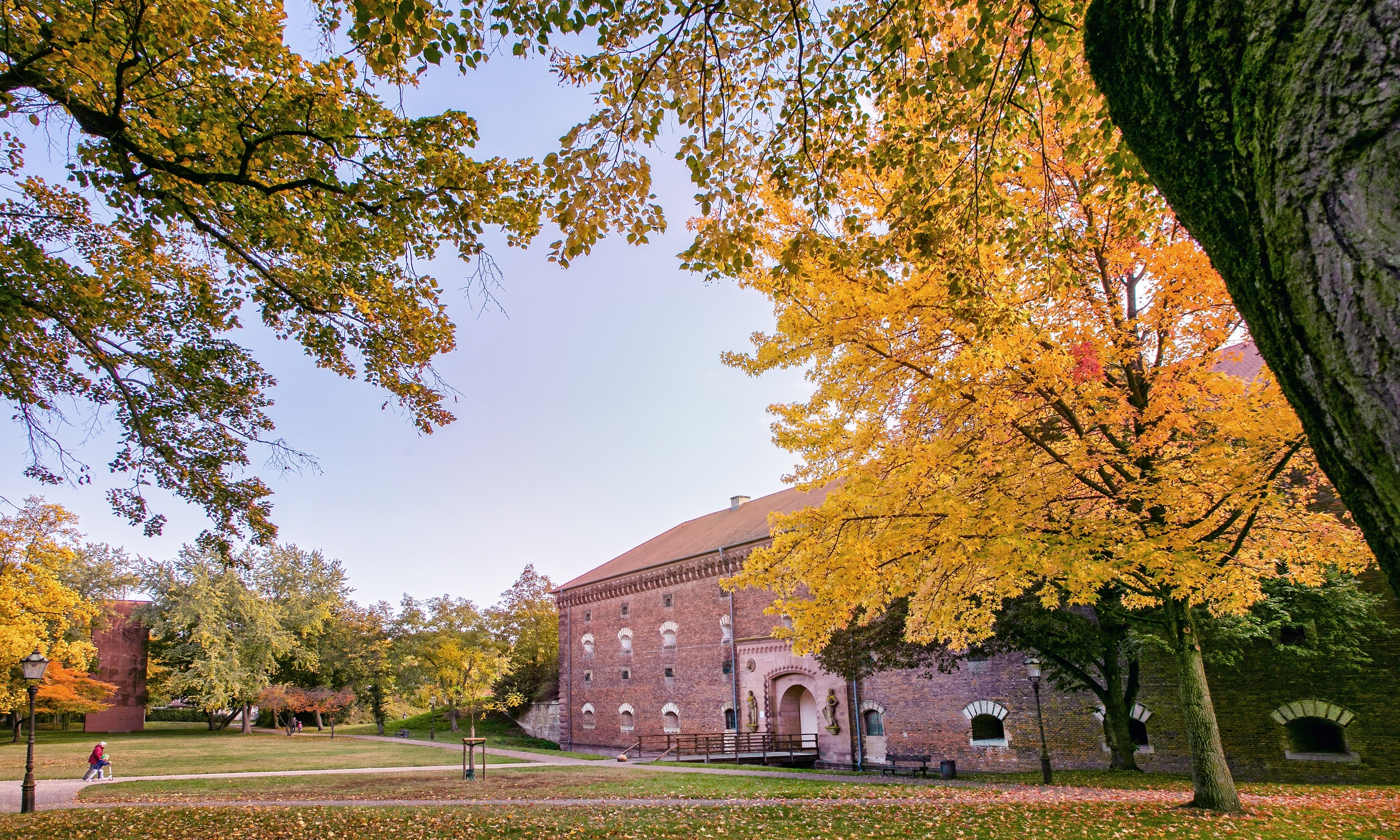 Ludwigstor mit Vorplatz und herbstlich gefärbten Bäumen