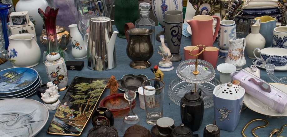 Flohmarkttisch mit Gläsern, Vasen und Tellern