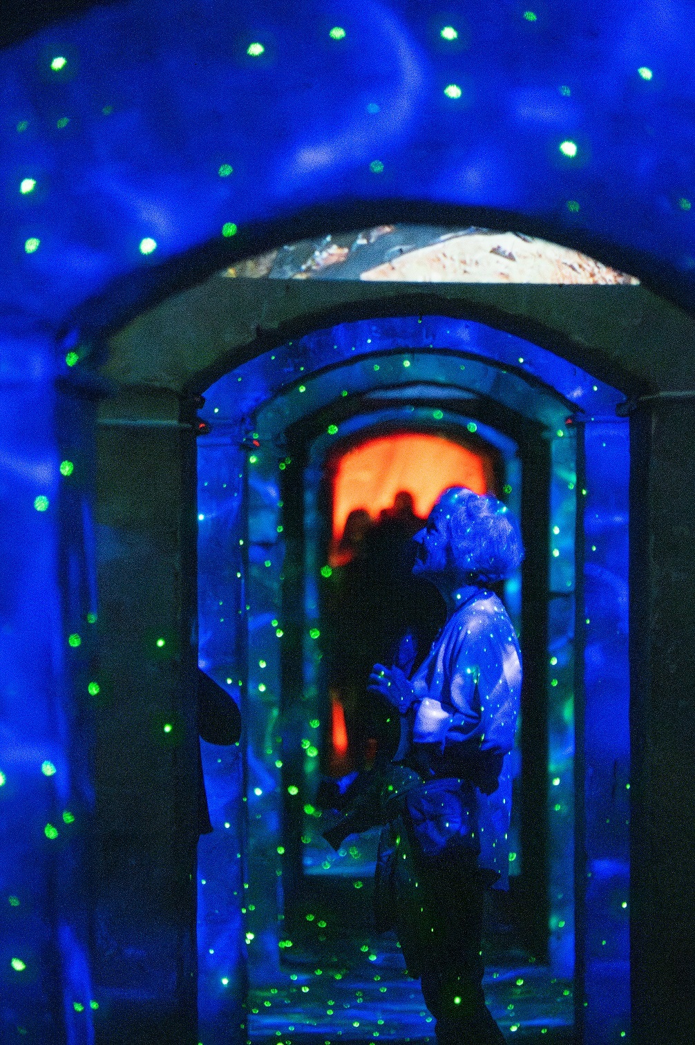 Mit Lichteffekten beleuchteter Festungsgäng. Blauer Hintergrund mit gelben Punkten, an einen Sternenhimmel angelehnt.