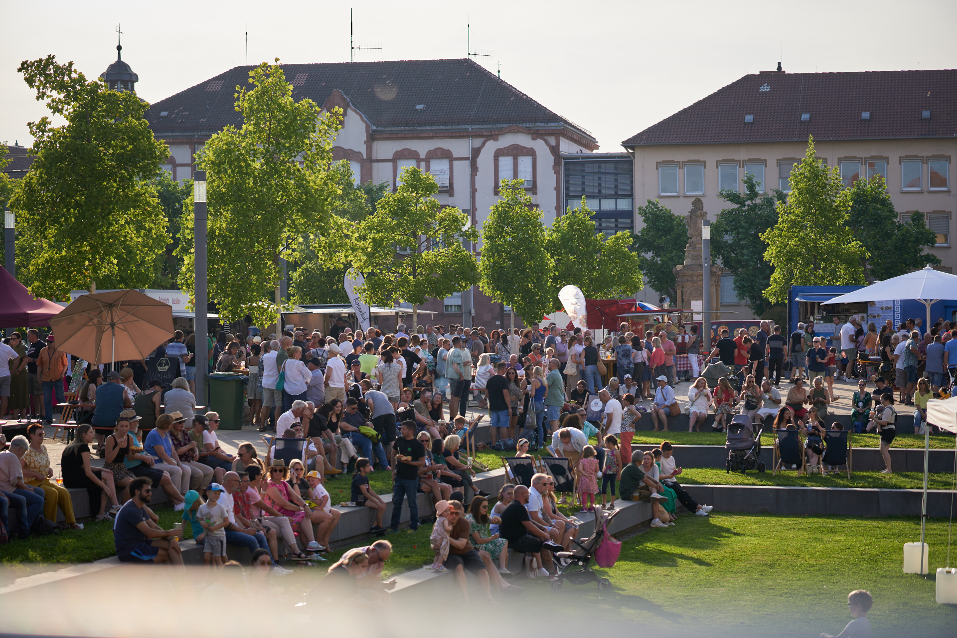 Ein Bild von der Wiese vom Paradeplatz. Im Hintergrund stehen Marktstände und es herrscht ein buntes Treiben mit vilen Leuten auf dem Platz und der Wiese