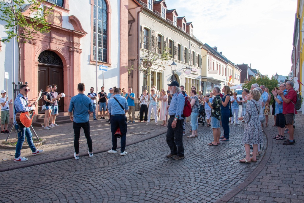 Teilnehmer des Stadtwalks in der Germersheimer Innenstadt vor einer Walk-Station