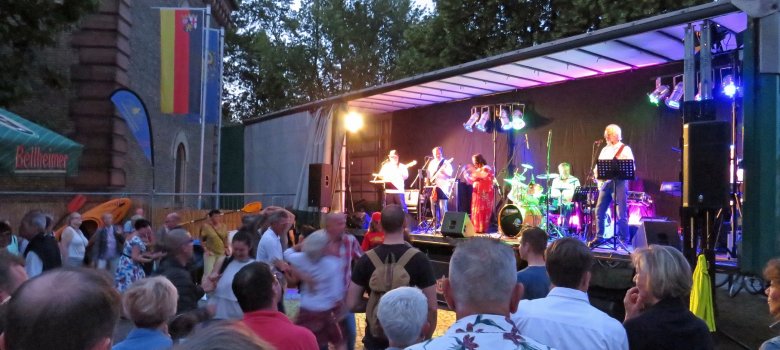 Besucher vor der Festbühne, Band mit Livemusik auf der Bühne