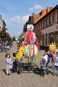 Kleiner Festwagen mit Schneemannstatue in Germersheim für die Winterverbrennung, Kita-Gruppe am Festwagen