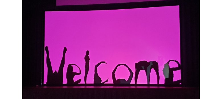 Schattentheater Text "Welcome" vor einem lilafarbenen Hintergrund