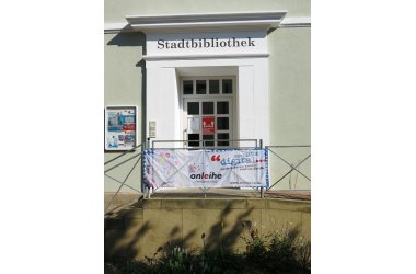 Eingang der Stadtbibliothek mit Infoplakat Onleihe Rheinland-Pfalz