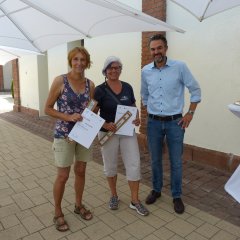 Zusehen ist der 1. Beigeordnete Sascha Hofmann mit zwei Gewinnerinnen der Kanusportgemeinschaft