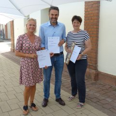 Zusehen ist der 1. Beigeordnete Sascha Hofmann mit zwei Gewinnerinnen aus dem Team der Stadtverwaltung Germersheim