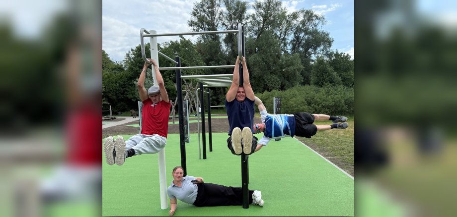 Turngerüst an der neuen Calisthenics-Anlage im Germersheimer Rheinvorland. Vier Personen turnen unterschiedliche Übungen am Gerät.