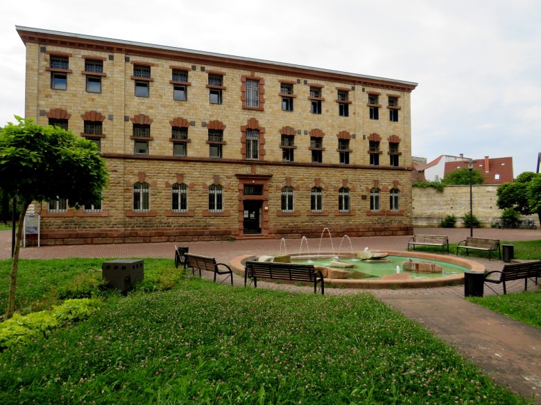 Seitenansicht historisches Arrestgebäude inkl. Grünfläche und Springbrunnen